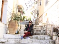Fruen siddende på trappen til en af de mange små passager i Athen